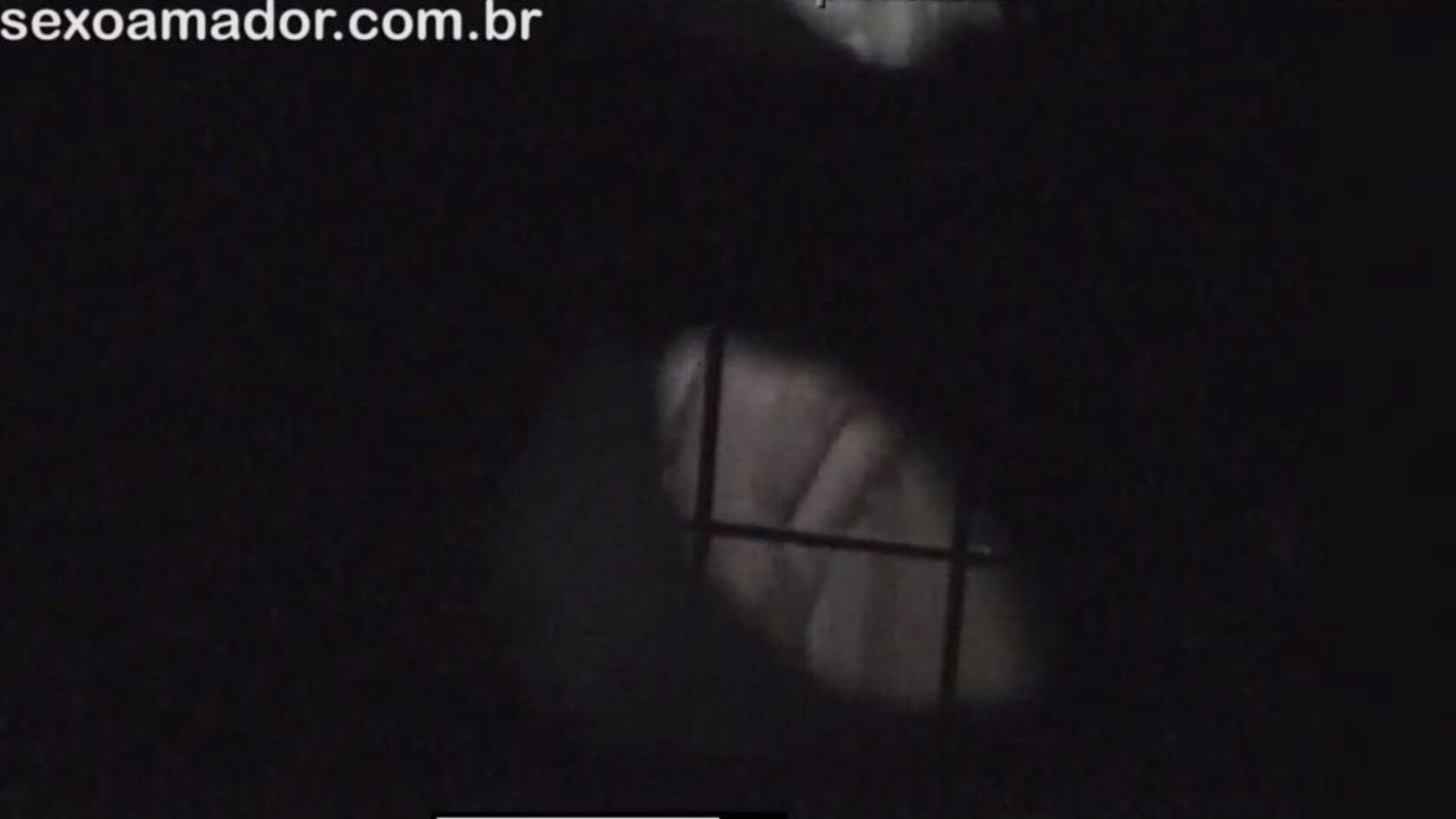 rubia es filmada en secreto por un vecino voyeur encubierto detrás de ladrillos huecos